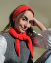 eine frau trägt ein haarband und ein minischal aus merinowolle in der farbe orange