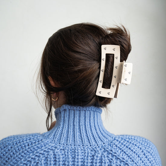 große haarklammer im haar von einer frau im blauen pullover