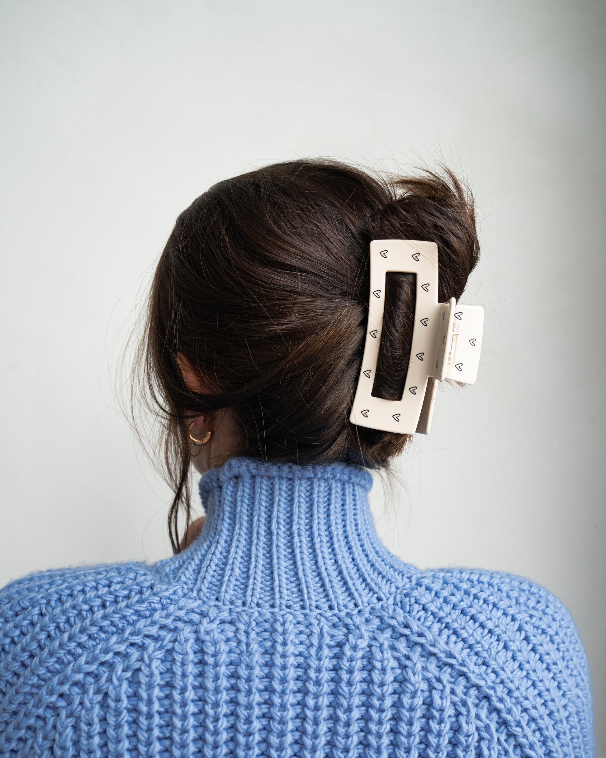 große haarklammer im haar von einer frau im blauen pullover