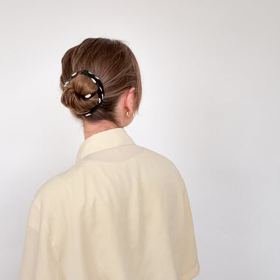 rückansicht einer frau mit längeren haaren, die ein schwarzes drahthaarband im bunstyle trägt