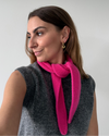 eine frau trägt einen mini schal in pink aus merinowolle