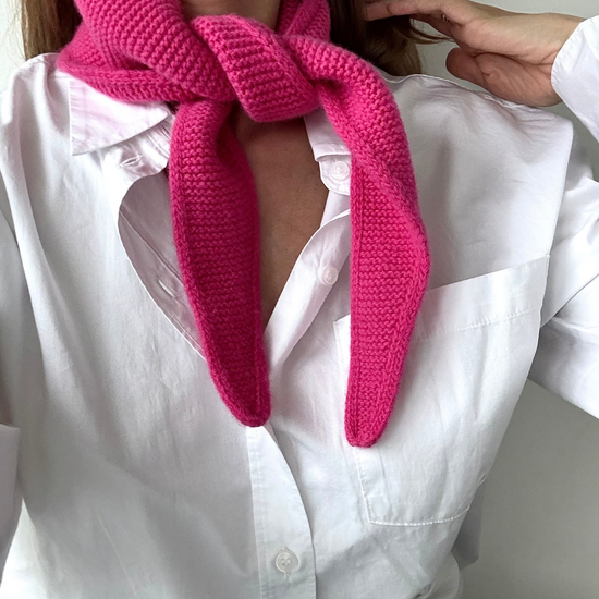 eine frau trägt einen mini schal in pink aus merinowolle